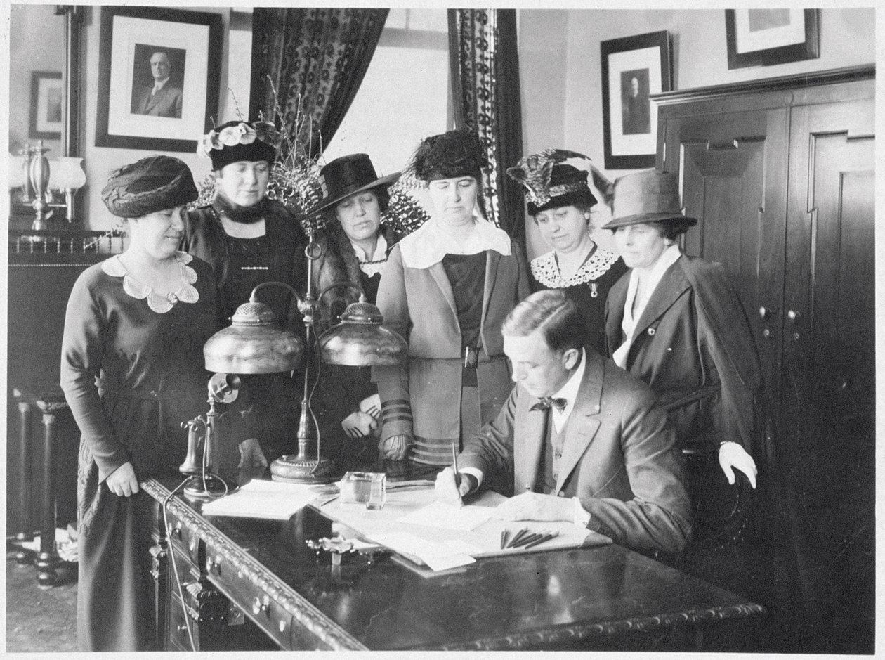 カールエリアスミリケン知事、6人の女性が見守る中、選挙法案に署名1917 作： アメリカの写真家