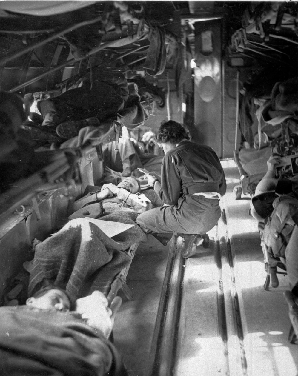 北アフリカへの飛行中に患者を治療しているサウスカロライナのメアリースミスさん（1943-45年頃）、コマンドー協会がまとめた650枚の写真集 作： アメリカの写真家