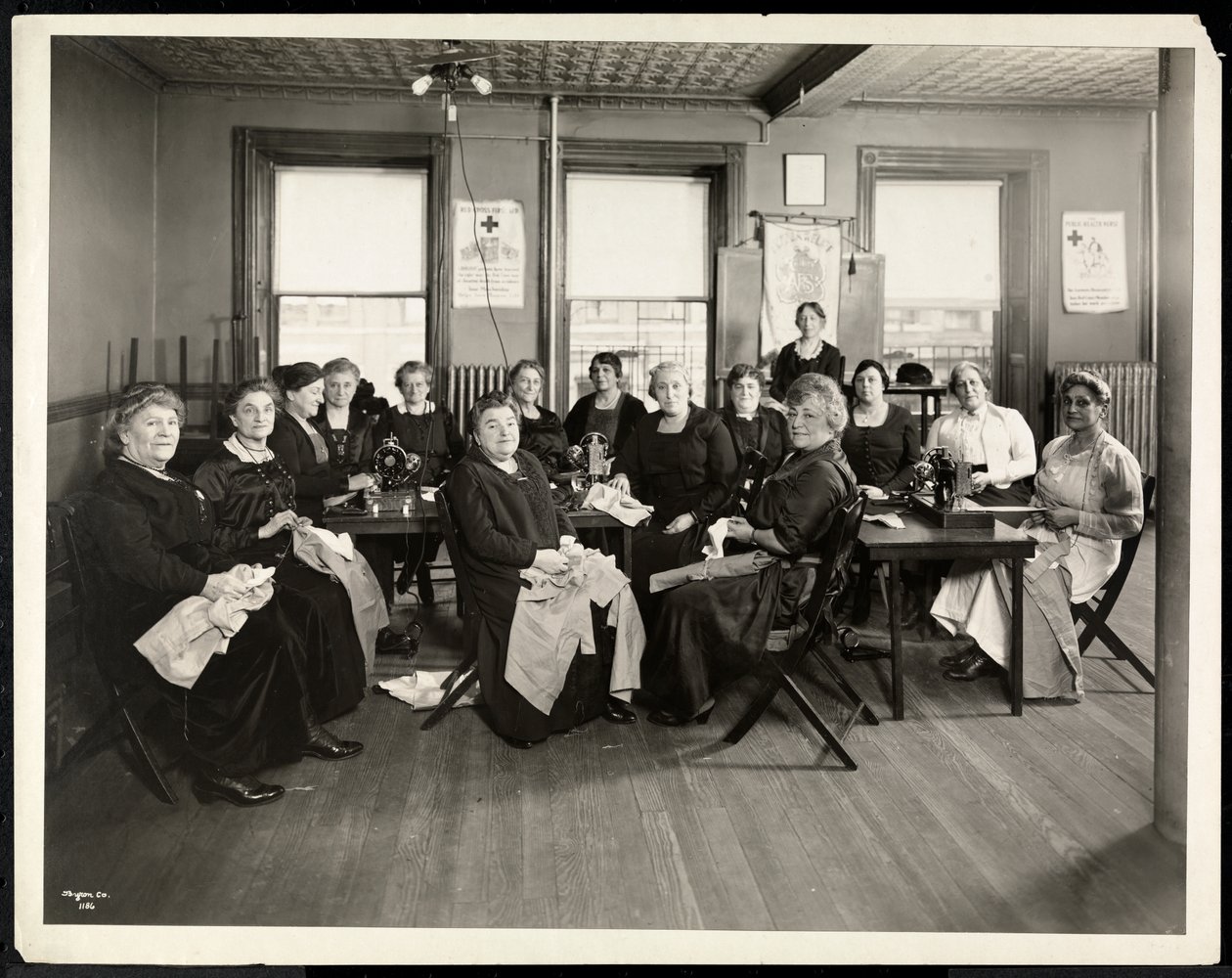 1920年、ニューヨーク州イーストハーレム、115 East 101st Street、115番地にあるアメリア救済協会の女性用縫製サークル（シルバーゼラチンプリント） 作： バイロンカンパニー