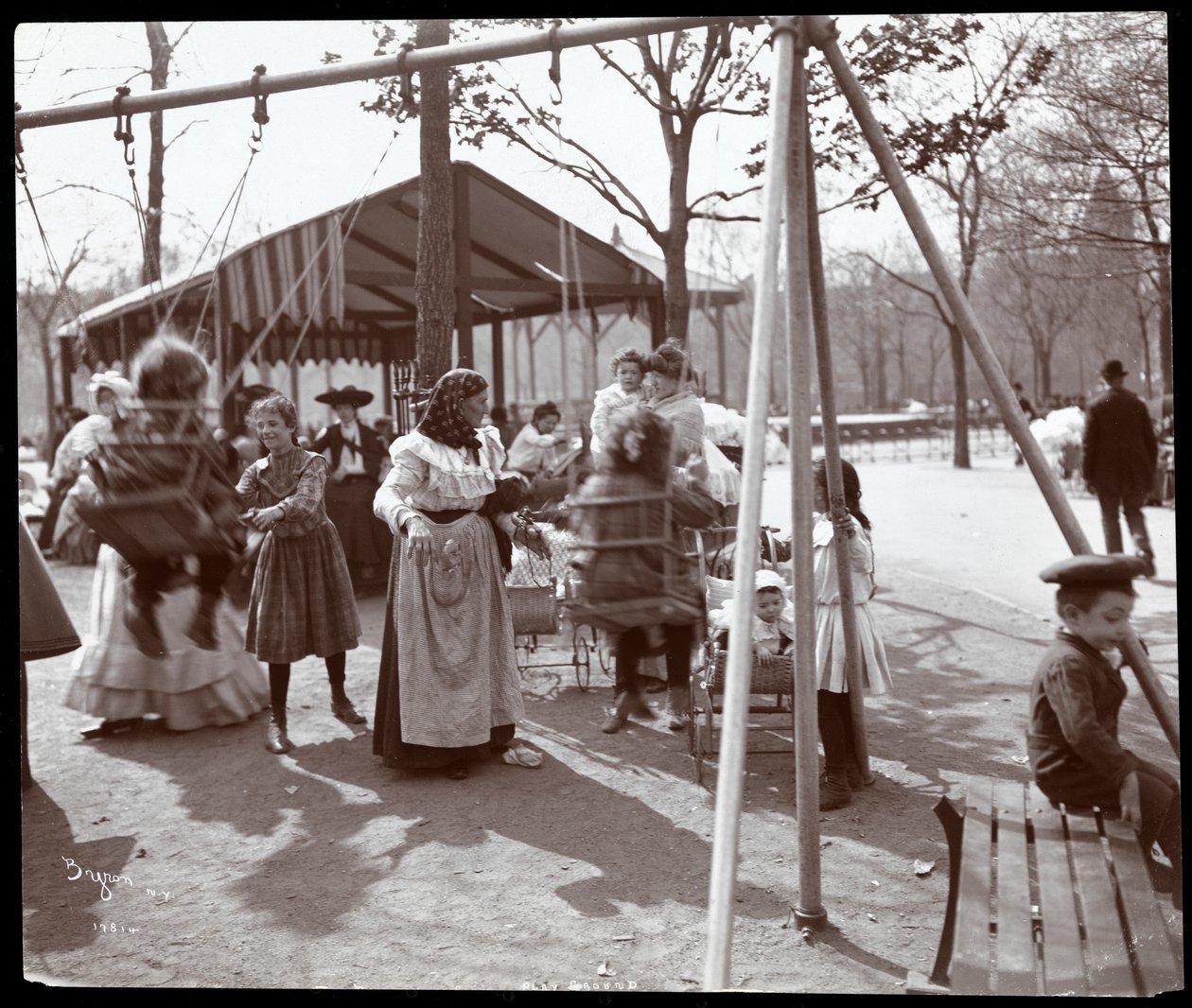 1904年ニューヨークのアーバーデーに、トンプキンススクエアパークのブランコで子供たちを押す女性の様子（シルバーゼラチンプリント） 作： バイロンカンパニー