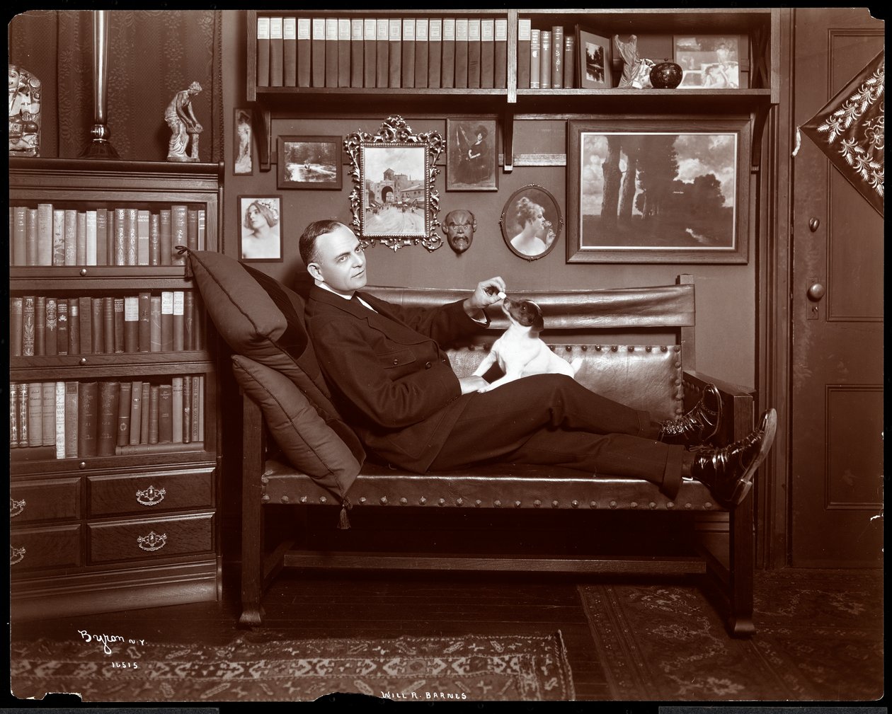 ウィルR.バーンズは、1903年に彼の図書館のスタジオで犬と一緒にソファーにリクライニングしました（シルバーゼラチンプリント） 作： バイロンカンパニー