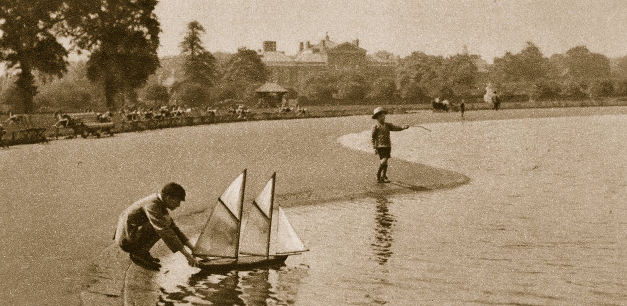 ケンジントンガーデンズのラウンドポンドで子供たちがモデルボートでレースをしている、1926年（セピア写真） 作： 英語の写真家