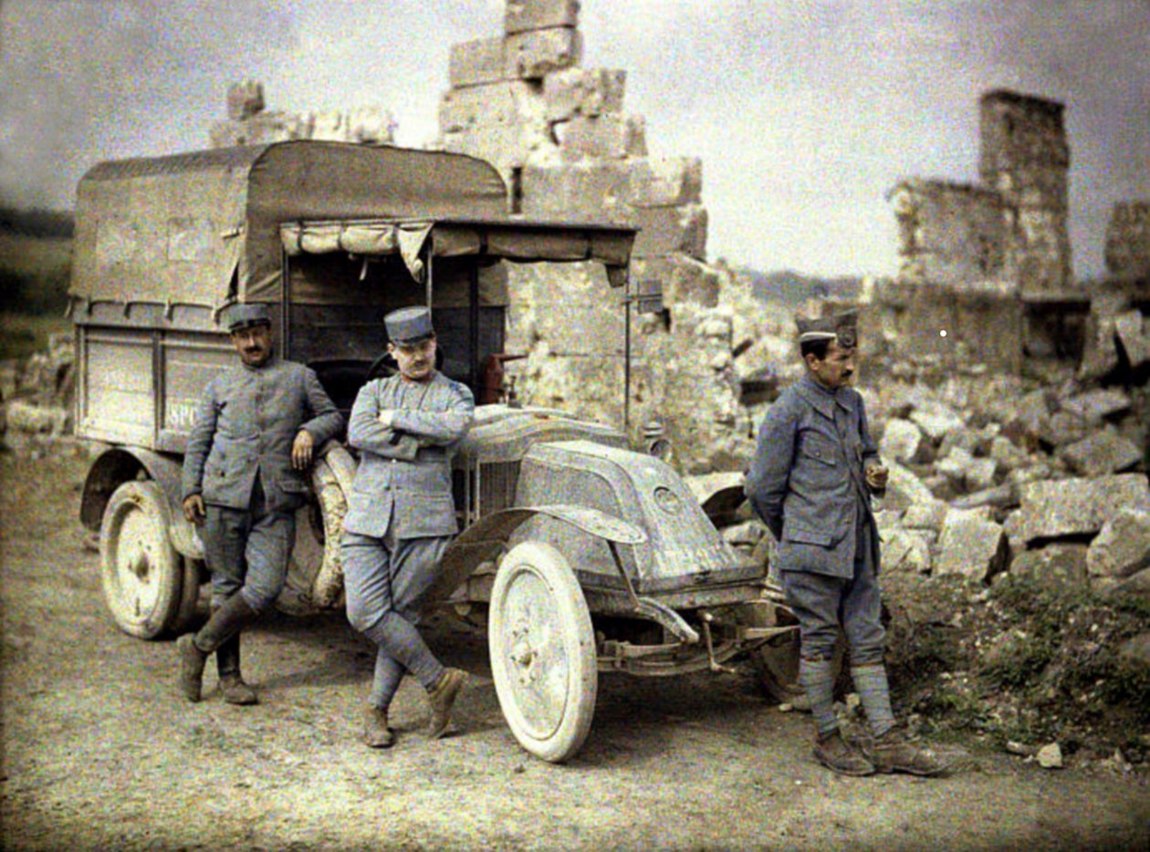1917年にフランスのエーヌにある小型トラックで大きな被害を受けた建物の前にフランス人兵士3人が駐車（オートクローム） 作： フェルナンド・キュービル