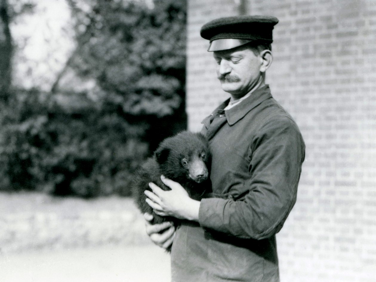 1921年8月、ロンドン動物園で飼育係がナマケモノの子を飼っています。 作： フレデリックウィリアムボンド