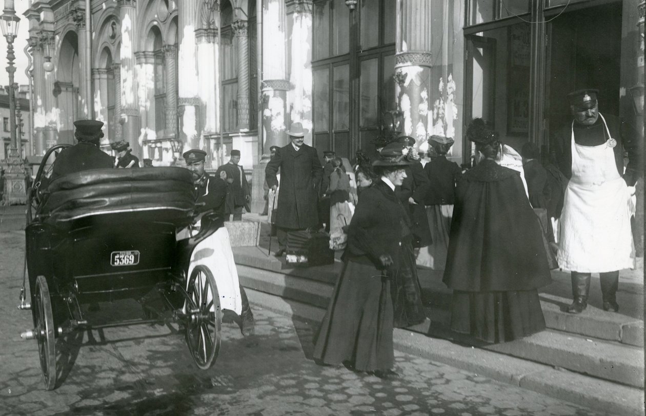1913年頃、サンクトペテルブルクのネフスキー大通り、ニコラス駅の外にいるポーターと乗客 作： ロシアの写真家