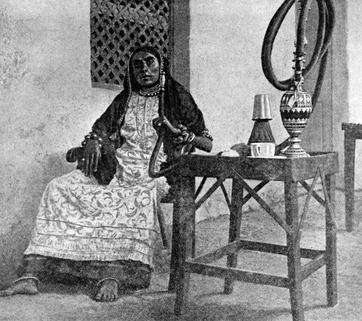 水ギセルを吸っているソマリアの女性、アデン、1922 作： 不明