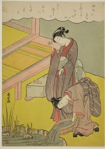 池に魚を投げる少女