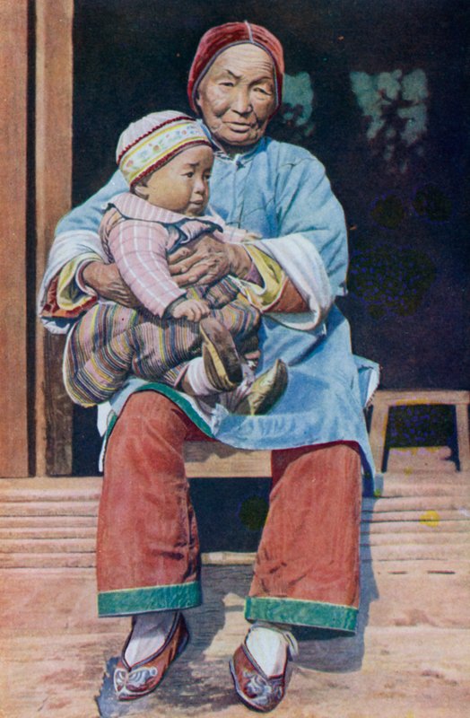 ズボンをはいて、孫と一緒に中国人の祖母 作： 英語の写真家